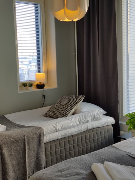 Tampereen Takamaanrinteellä sijaitsevan kalustetun asunnon makuuhuone tyylikkäillä yhden hengen sängyillä
